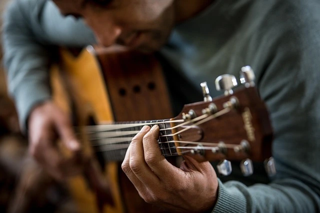 Leaning over the guitar while playing.